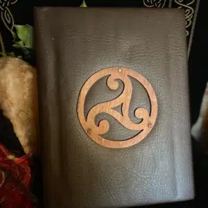 Grimoire en simili-cuir marron avec triskel en bois.