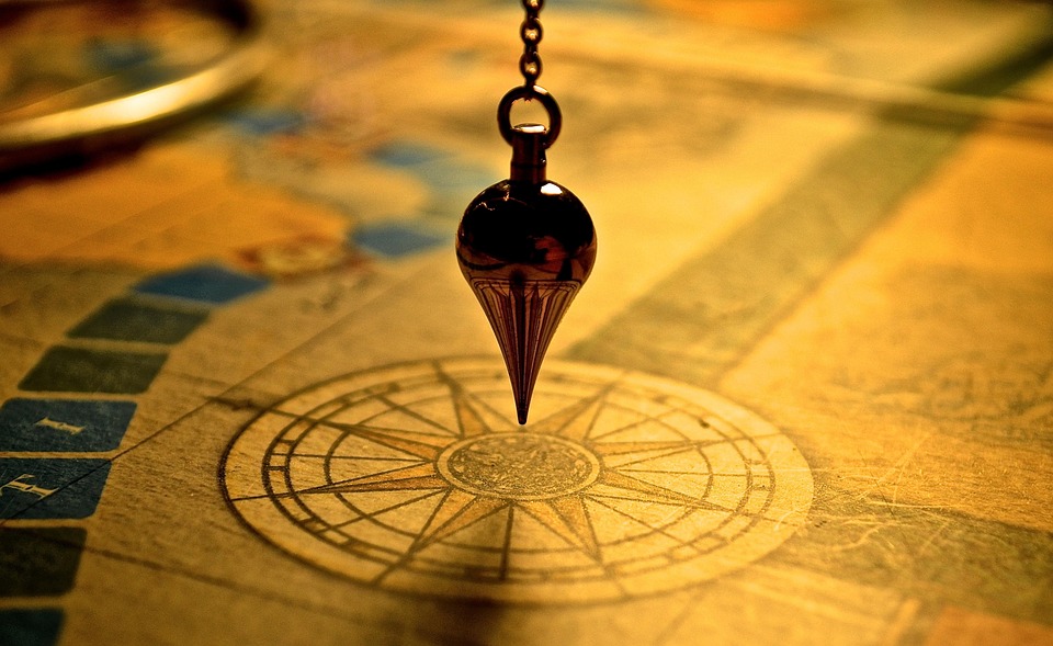 Pendule en laiton pendant au-dessus d'une rose des vents.